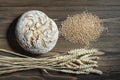 Fresh baked wheat bread loaf, a ghandful of wheat grain and wheat ears on a dark brown wooden background Royalty Free Stock Photo