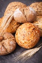 Fresh baked rolls with seeds and ears of rye or wheat grain Royalty Free Stock Photo