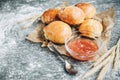 Fresh baked yeast buns filled with apple jam on gray background with flour