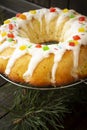 Fresh baked yeast cake or brioche with icing on dark wooden table