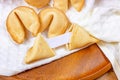 Fresh baked yellow Chinese fortune cookies with white blank note inside on light background. Royalty Free Stock Photo