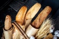 Fresh bakery products in the form of four loaves in degradable paper eco-packaging and a bouquet of wheat in a wicker