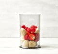 Fresh banana pieces and red berries in plastic transparent blender container Royalty Free Stock Photo