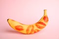 Fresh banana with red lipstick marks on pink . Oral sex concept