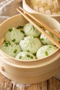 Fresh baozi in bamboo steamer on Chinese Asian food closeup. vertical