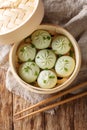 Fresh baozi in bamboo steamer on Chinese Asian food closeup. Vertical top view