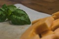 fresh basil placed next to sliced canaloupe on a countertop