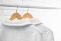 Fresh bathrobes hanging on rack near brick wall Royalty Free Stock Photo