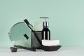 Fresh bathroom interior in green mint menthe color - black razor, toothbrush, soap, towel, mirror, dispenser on white wood table. Royalty Free Stock Photo