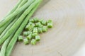 Fresh beans on wooden chopping board with one of the beans slice