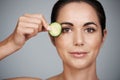 Fresh beauty secrets. Studio shot of a beautiful mid adult woman holding a slice of cucumber to her face. Royalty Free Stock Photo