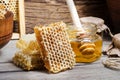 Fresh bee Honey in honeycombs and in a glass jar with a honey dipper on a wooden background Royalty Free Stock Photo