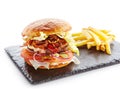 Fresh Beef Burger with Bacon, Fried Onions, Tomato Sauce, Pickled Cucumbers, Green Lettuce, Cheese and French Fries Garnish. Hambu Royalty Free Stock Photo