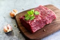 Fresh beef piece for steak or grilled barbecue / Raw meat beef steak with spices garlic on wooden cutting board and black Royalty Free Stock Photo