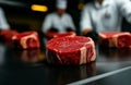 Fresh beef steak on production line with workers in background, showcasing meat processing in factory setting. atmosphere is Royalty Free Stock Photo