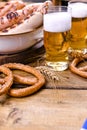 Fresh beer with foam on a wooden background. Oktoberfest German Pretzels