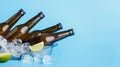 Fresh beer at hot day. Dark glass bottles in glass tray with ice and lime on blue background Royalty Free Stock Photo