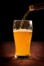 Fresh beer pouring from bottle into glass Royalty Free Stock Photo