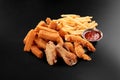 Fresh beer snacks chicken wings french fries cheese sticks assortment on black Royalty Free Stock Photo