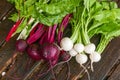 Fresh beets and turnips with greens on a rustic wood table