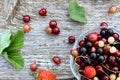 Fresh berries of cherry, gooseberry, currant lie on a glass plate and scattered around it