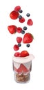 Fresh berries falling into glass with yogurt and granola on white background Royalty Free Stock Photo