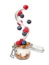 Fresh berries falling into jar cup with yogurt and granola on white background Royalty Free Stock Photo