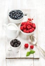 Fresh berries and milk in pitcher on white wooden background Royalty Free Stock Photo