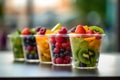 Fresh berries and pieces of fruit in plastic glass to take away as a snack. Kiwi, strawberry, mango, blackberry in cup