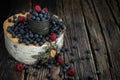 Fresh berries raspberries and blueberries in a cup. The berries are scattered on a birch stump. Birch cut. Vintage metal