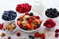 Fresh berries strawberry, raspberries and natural flakes for breakfast, Woman pouring milk into bowl with muesli top Royalty Free Stock Photo