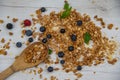 Fresh berries and wood spoon full whit granola, top view. Royalty Free Stock Photo