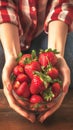 Fresh berry bounty Womans hands hold a bowl of strawberries