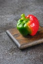 Fresh bicolor red and green bell pepper with water droplets on black concrete background Royalty Free Stock Photo
