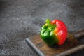 Fresh bicolor red and green bell pepper with water droplets on black concrete background Royalty Free Stock Photo