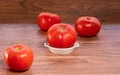 Fresh big red tomato on a white ceramic plate and more tomatoes in background