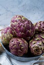 Fresh big Romanesco artichokes green-purple flower heads ready t Royalty Free Stock Photo