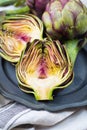 Fresh big Romanesco artichokes green-purple flower heads ready t Royalty Free Stock Photo