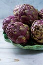 Fresh big Romanesco artichokes green-purple flower heads ready t Royalty Free Stock Photo