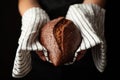 Fresh black bread on a towel in hands. Traditional homemade pastries