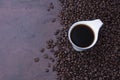 Fresh black coffee, a needle in a white coffee cup and fragrant roasted coffee beans, placed on a dark table Espresso coffee - Top Royalty Free Stock Photo