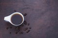 Fresh black coffee, a needle in a white coffee cup and fragrant roasted coffee beans, placed on a dark table Espresso coffee - Top Royalty Free Stock Photo