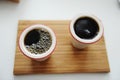 Fresh black filter coffee in two ceramic cups without handle on bamboo tray. White background. Top view, close up Royalty Free Stock Photo