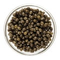 Fresh black papaya seeds in glass bowl over white