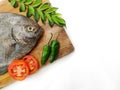 Fresh Black Pomfret Fish decorated with herbs and vegetables on a wooden pad Selective focus.Space for text Royalty Free Stock Photo