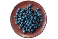 Fresh blackberries or blueberries in a brown clay ceramic plate photographed from above.