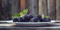 Fresh blackberries on a white plate with green leaves Royalty Free Stock Photo