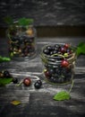 Fresh blackcurrants in glass jars on shot on wooden garden bench Royalty Free Stock Photo