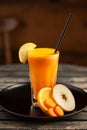 Fresh blended smoothie made of carrot, apple and orange.