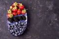 Fresh blueberries, blackberries, strawberries on a separate dish on a gray concrete background. view from above. vegetarian food. Royalty Free Stock Photo